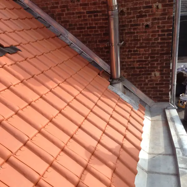 Raccord en zinc entre une toiture en tuiles et un mur mitoyen