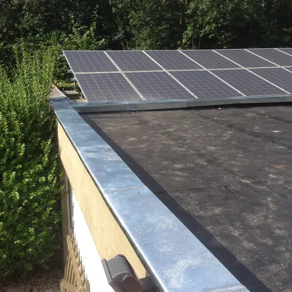Toiture plate avec rive en zinc et panneaux solaires