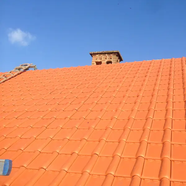 Versant en tuiles rouges neuves sous un ciel bleu