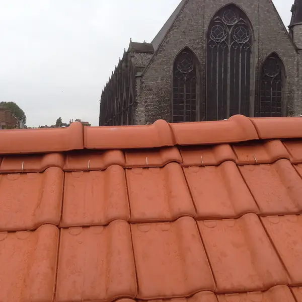 Faîtage en tuiles rouges neuves près d'une église